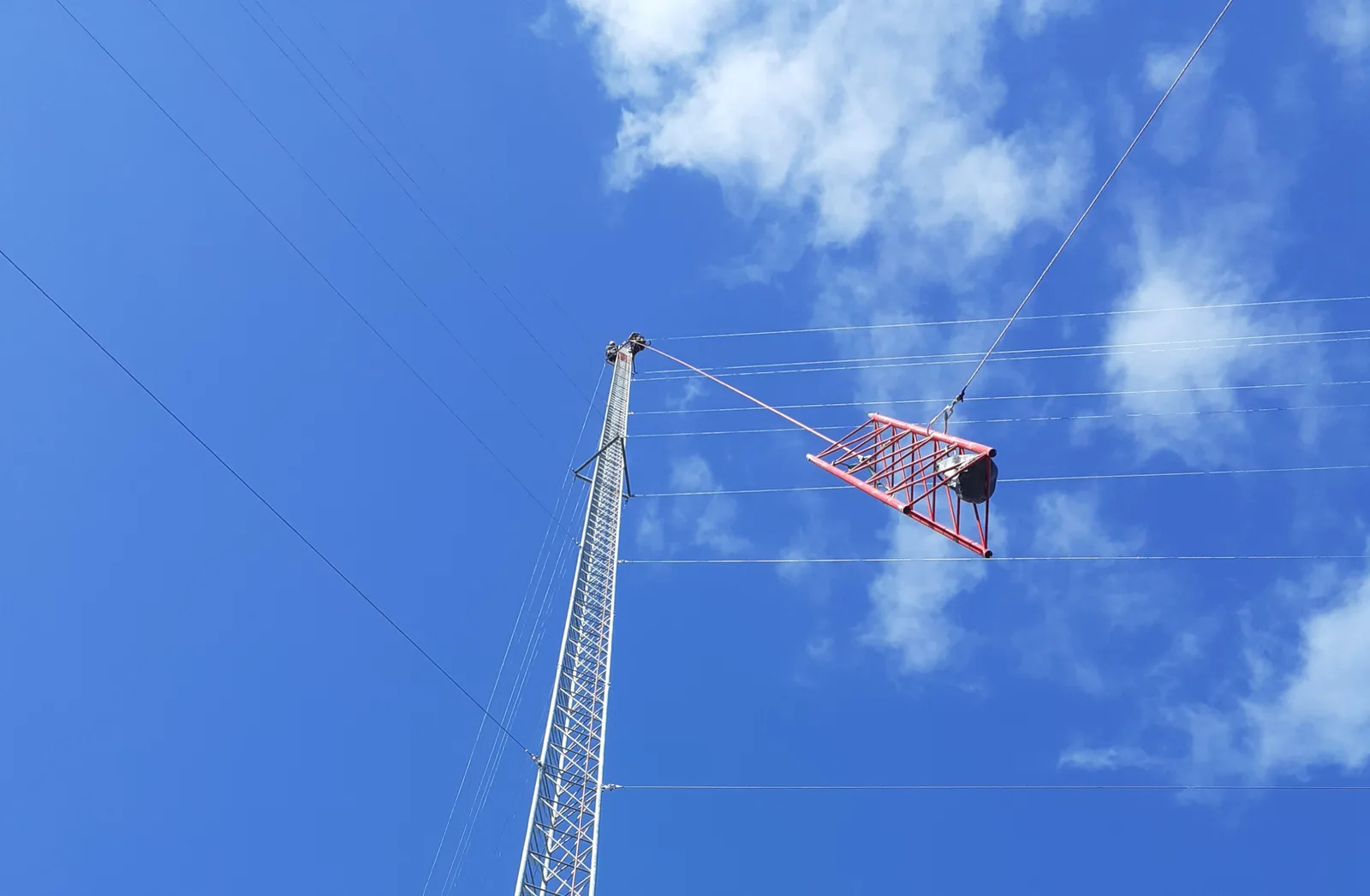 Traliccio anemometrico visto dal basso contro un cielo azzurro con nuvole